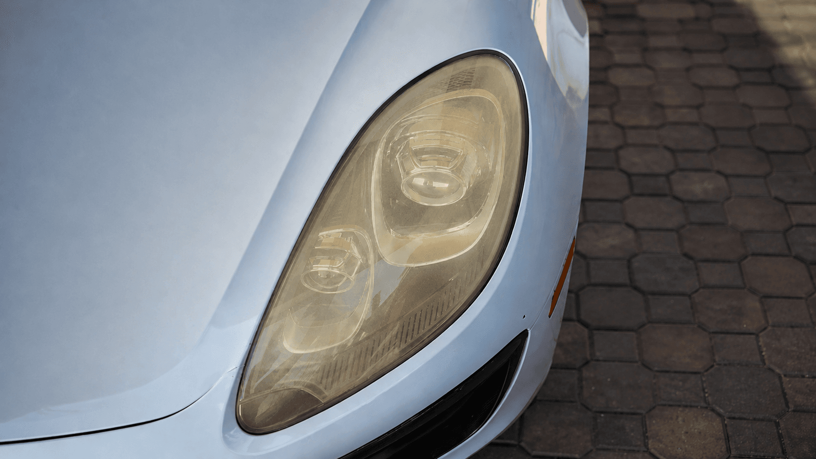 Before and after headlight restoration showing yellow hazy lens restored to clear